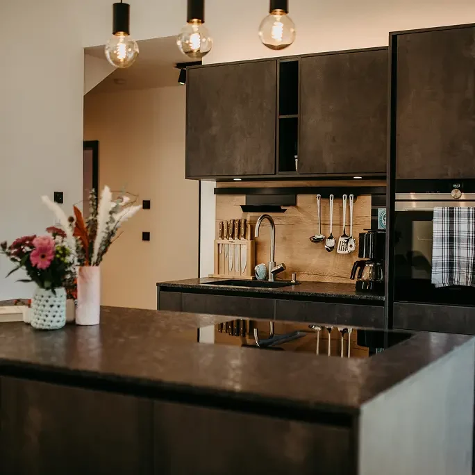 Moderne Küche mit dunkler Front, Kaffeemaschine und Kochinsel