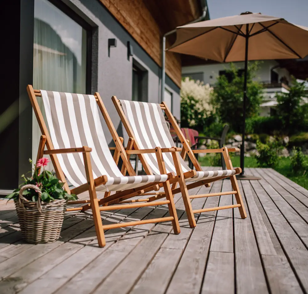 Gartenbereich mit Liegestühlen und Sonnenschirm