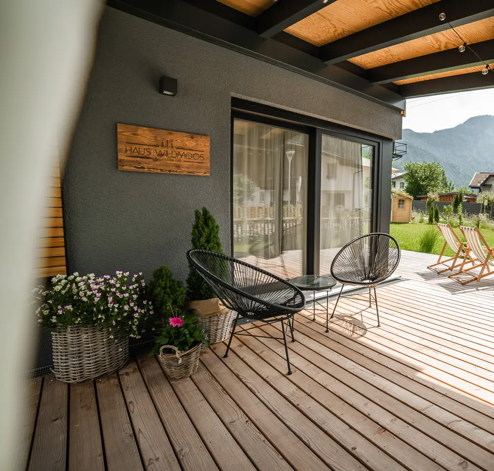 Holzterrasse mit Lounge-Stühlen zum Relaxen vor dem Chalet Wildmoos