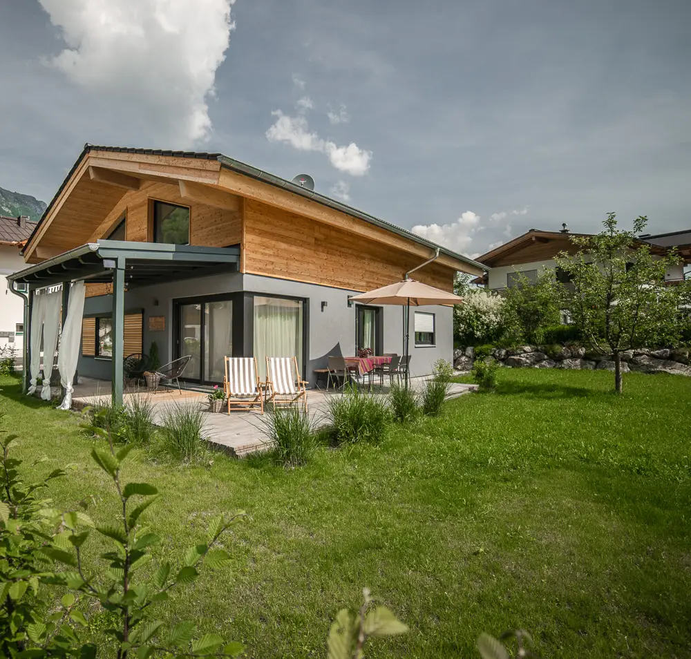 Haus Wildmoos im Grünen mit Garten und Bergen im Hintergrund