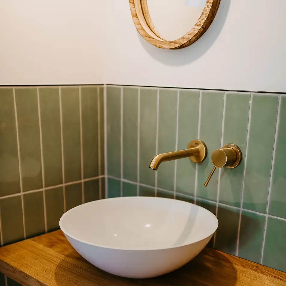 Waschbereich mit runder Schale und goldener Armatur – modernes Design