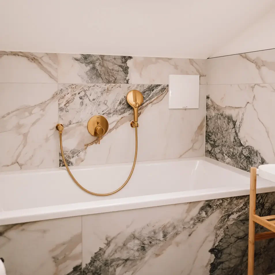 Marmorierte Badewanne mit goldener Armatur – stilvoll und luxuriös
