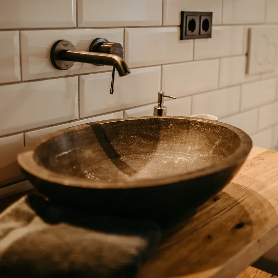Rustikales Waschbecken mit Naturstein-Schale im Bad im EG