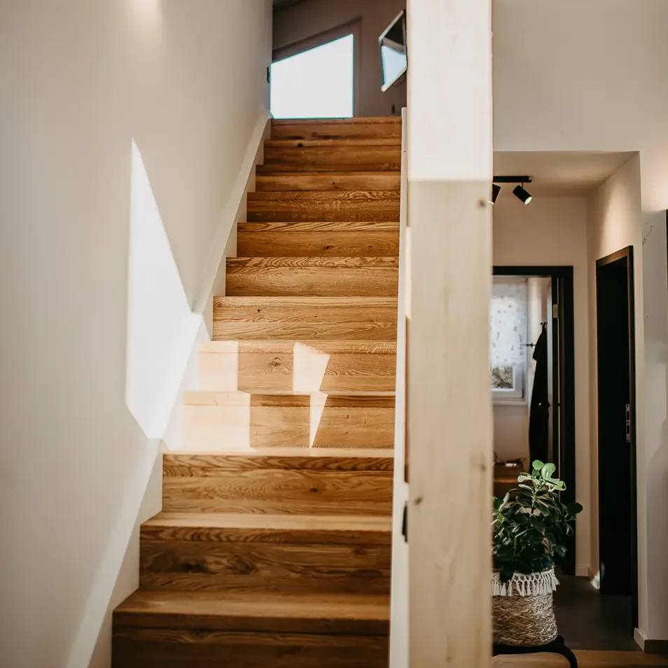 Holztreppe mit natürlichem Lichteinfall in den ersten Stock