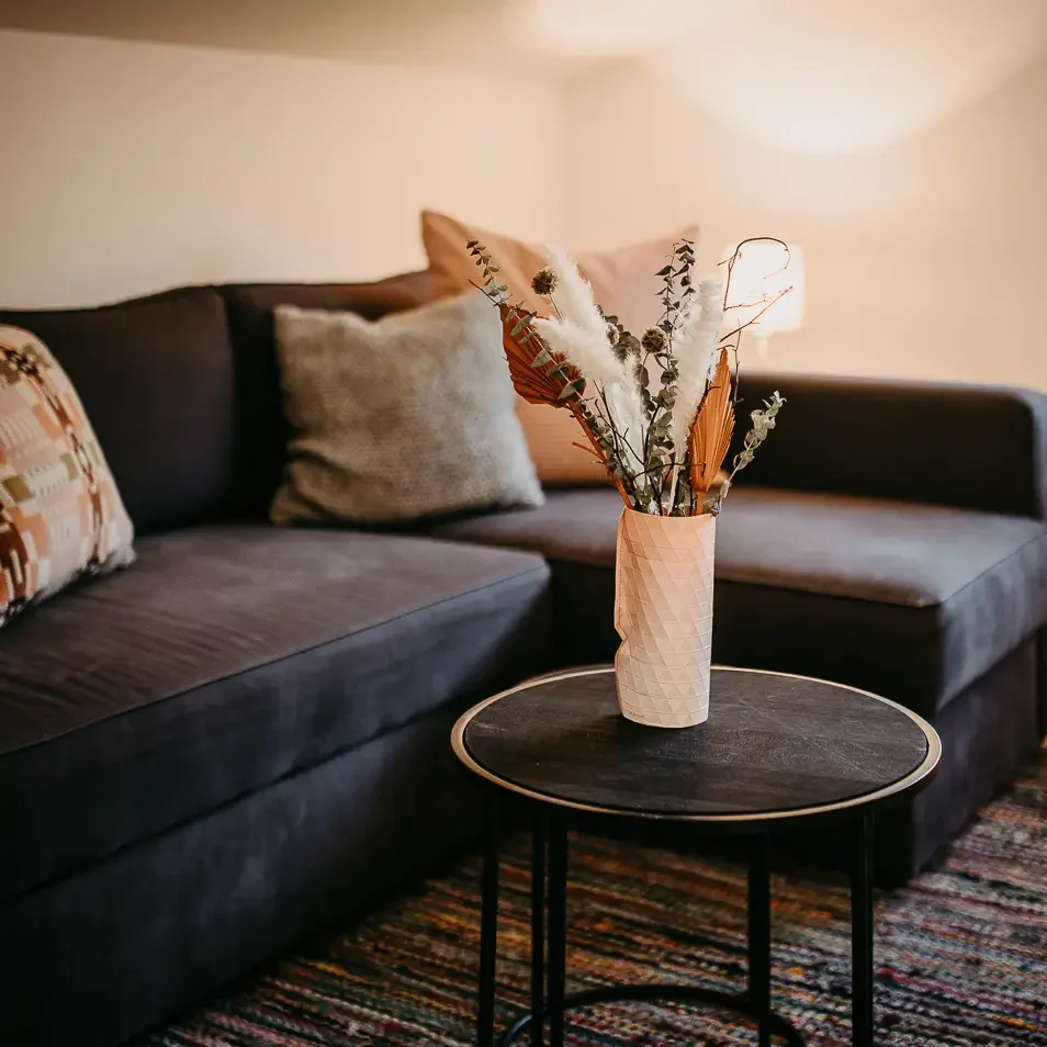 Dunkelblaues Sofa in der Galerie mit runder Vase auf dem Tisch